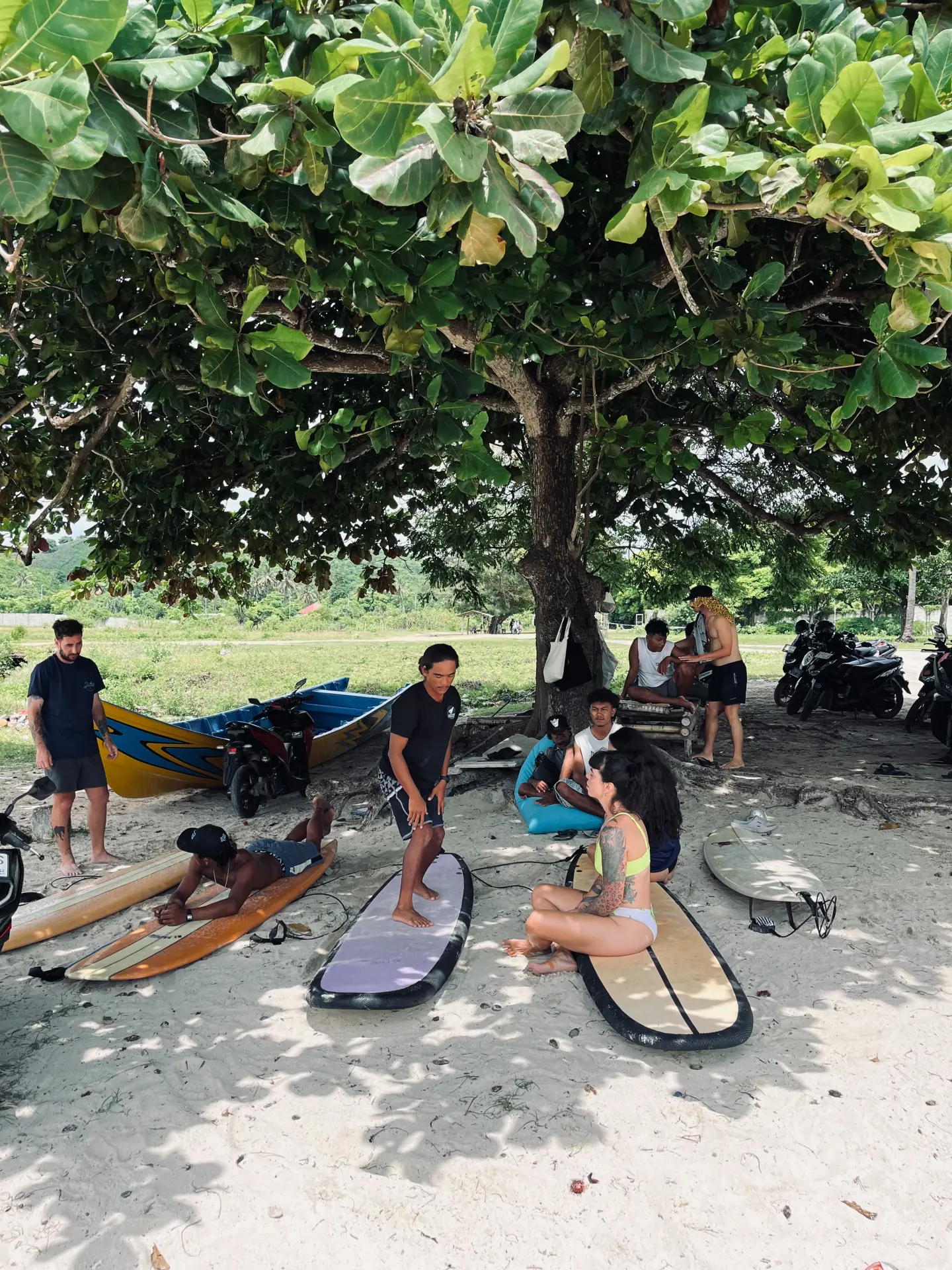 A surf coach demonstrating technique beneath the trees